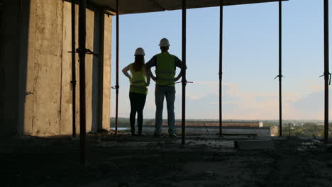 Construction-Business-:-teamwork-concept-:-Young-engineer-standing-behind-looking-at-a-building-site-wearing-a-safety-helmet